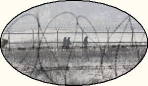 Guards patrol barbed fence in bleak winter